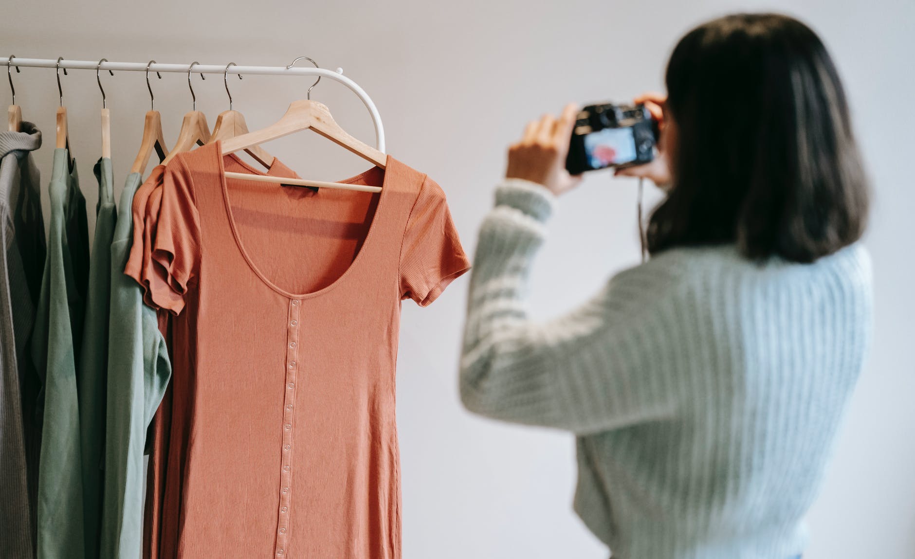 unrecognizable photographer taking photo of clothes on camera